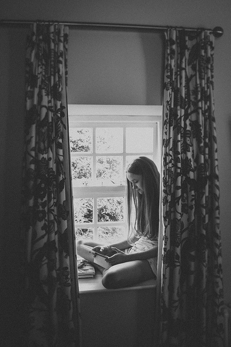 Bridesmaid reading in the window of Newton Hall, Northumberland