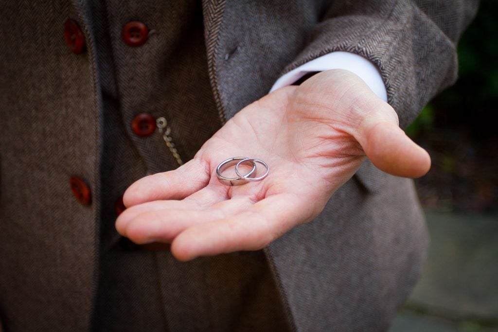 Wedding rings in the grooms hand at Brinkburn Priory