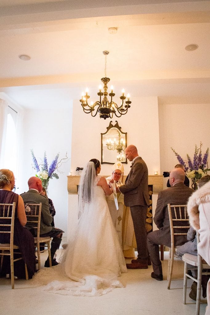 Bride & Groom being blessed in the white room at Brinkburn Priory Northumberland