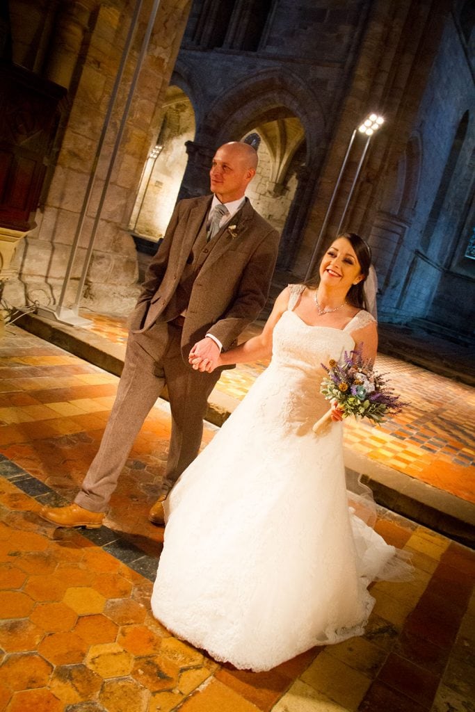 Bride & Groom walking through Priory Church
