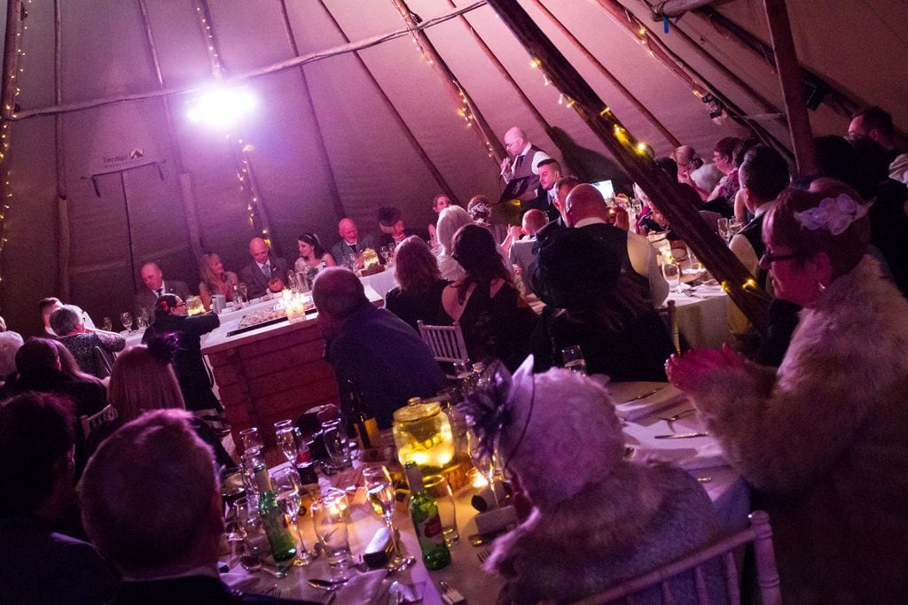 Guests watching speeches in the wedding tepee