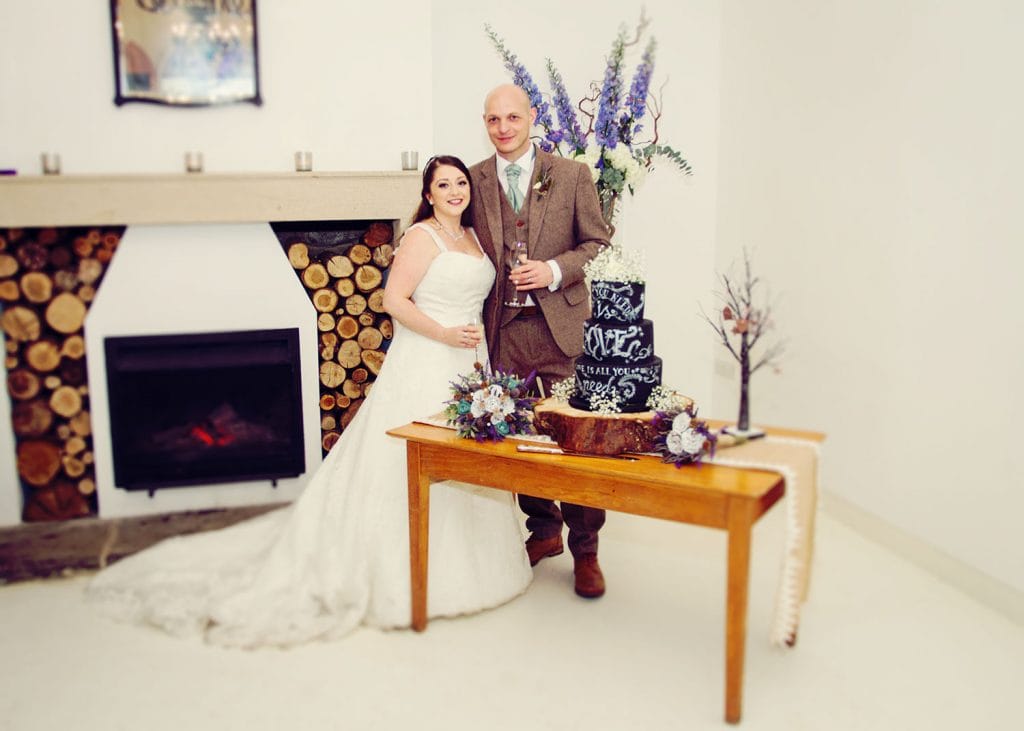 Bride & Groom with their Wedding Cake in the White room