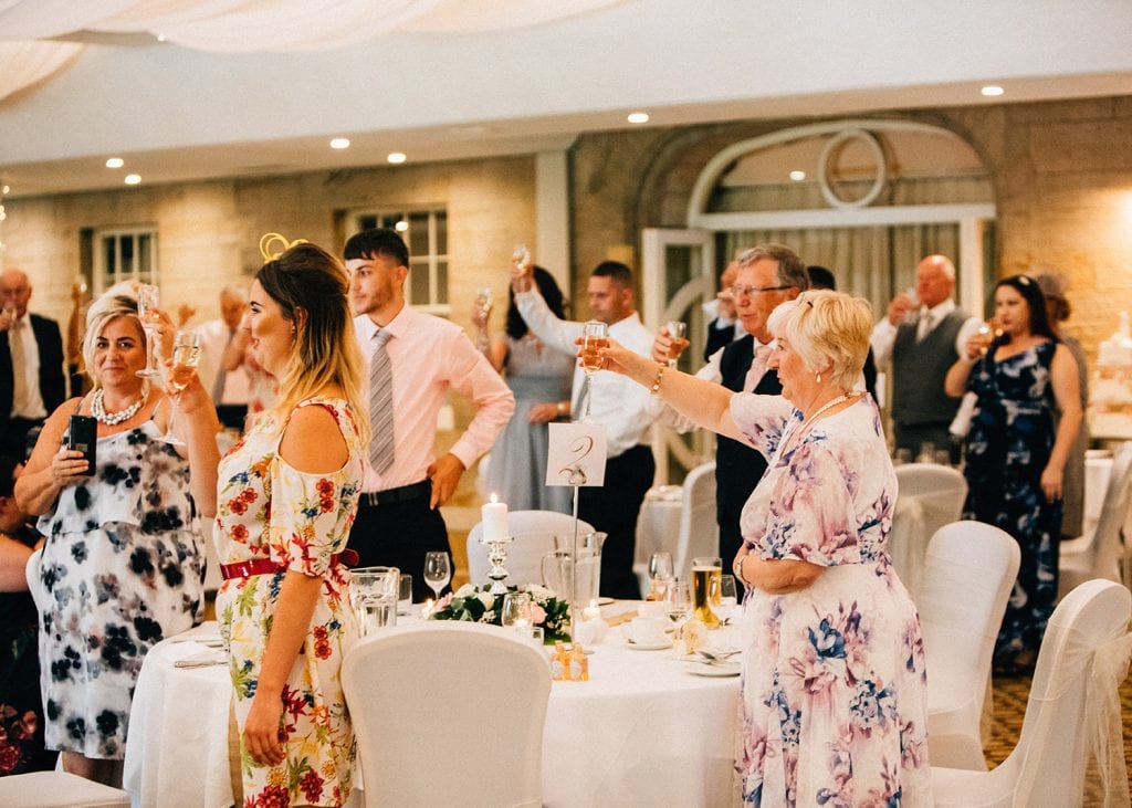 Guests toasting the bride & groom at Linden Hall in Northumberland