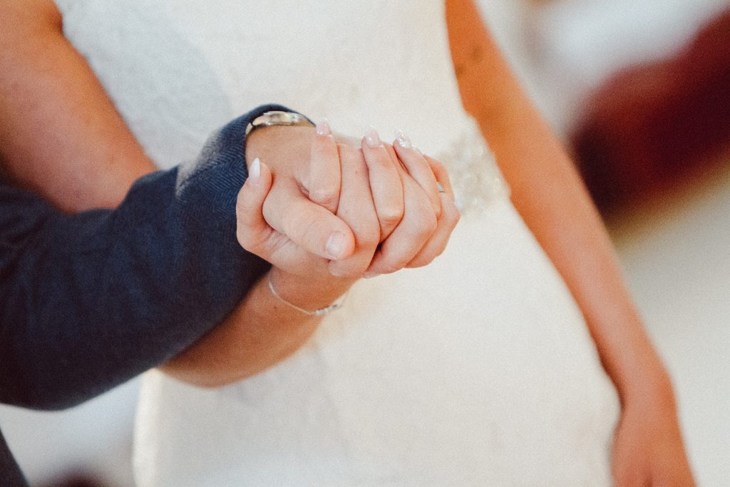 Close up of Bride & Groom holding hands