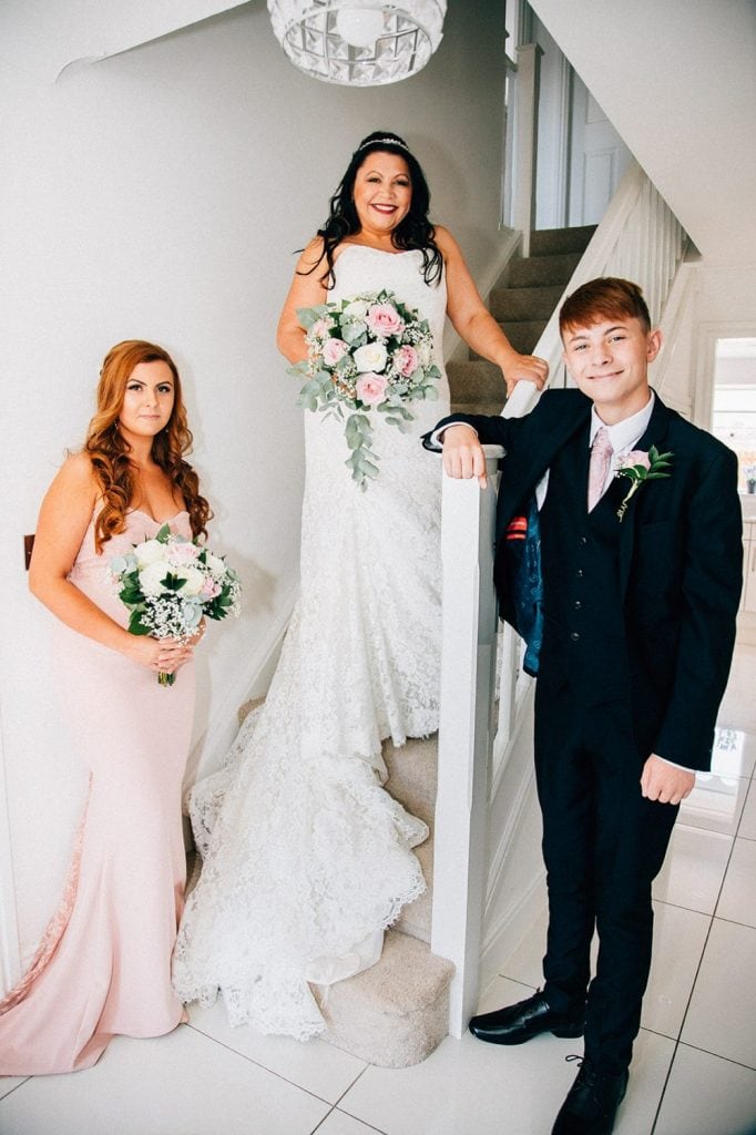 Bride and her children posing on their home staircase