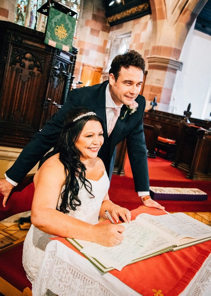 Bride & Groom signing register, St Cutherts Church in Blyth, Northumberland