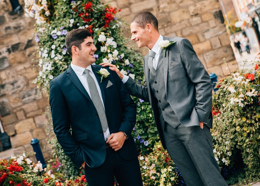 Groom and Bestman talking next to Morpeth clock tower in Northumberland