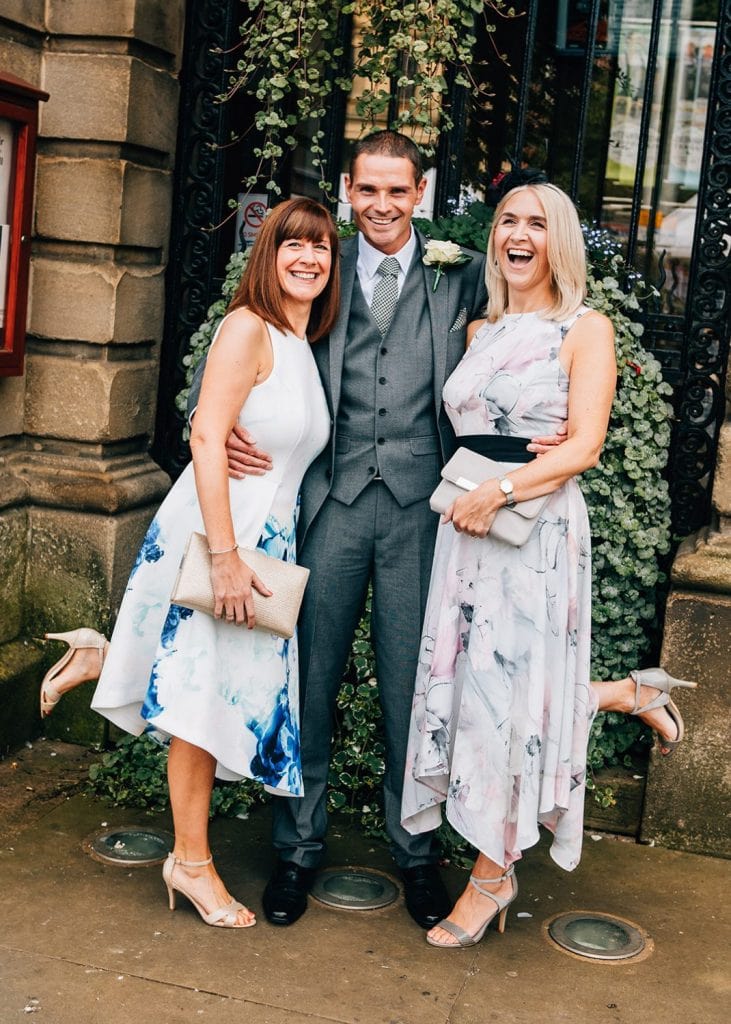 Groom having a hug from his sisters outside of Morpeth Town Hall in Northumberland
