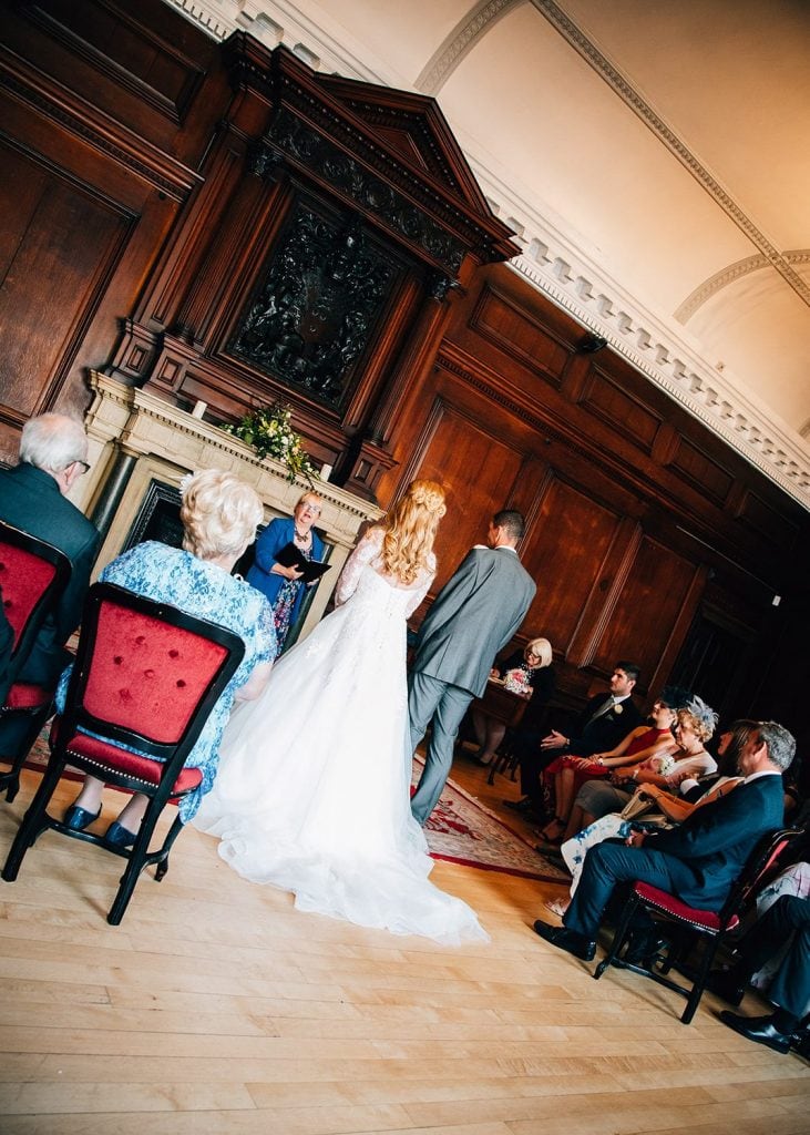 The bride & groom from behind listerning to the registrar in the Ballroom, Morpeth Town Hall in Northumberland