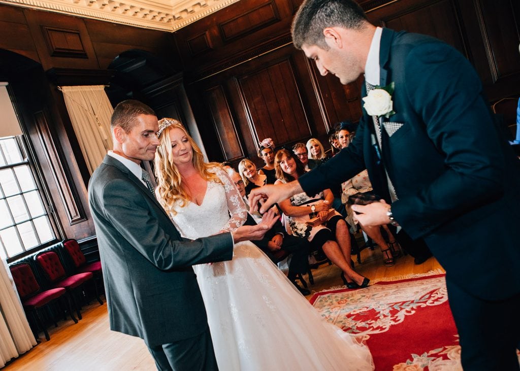 Bestman handing the rings to the groom listerning to the registrar in the Ballroom, Morpeth Town Hall in Northumberland