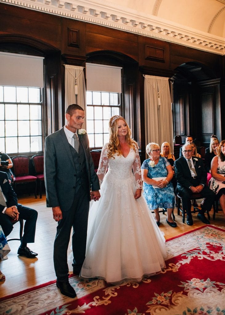 The Bride & Groom holding hands in the The Ballroom, Morpeth Registry Office in Northumberland