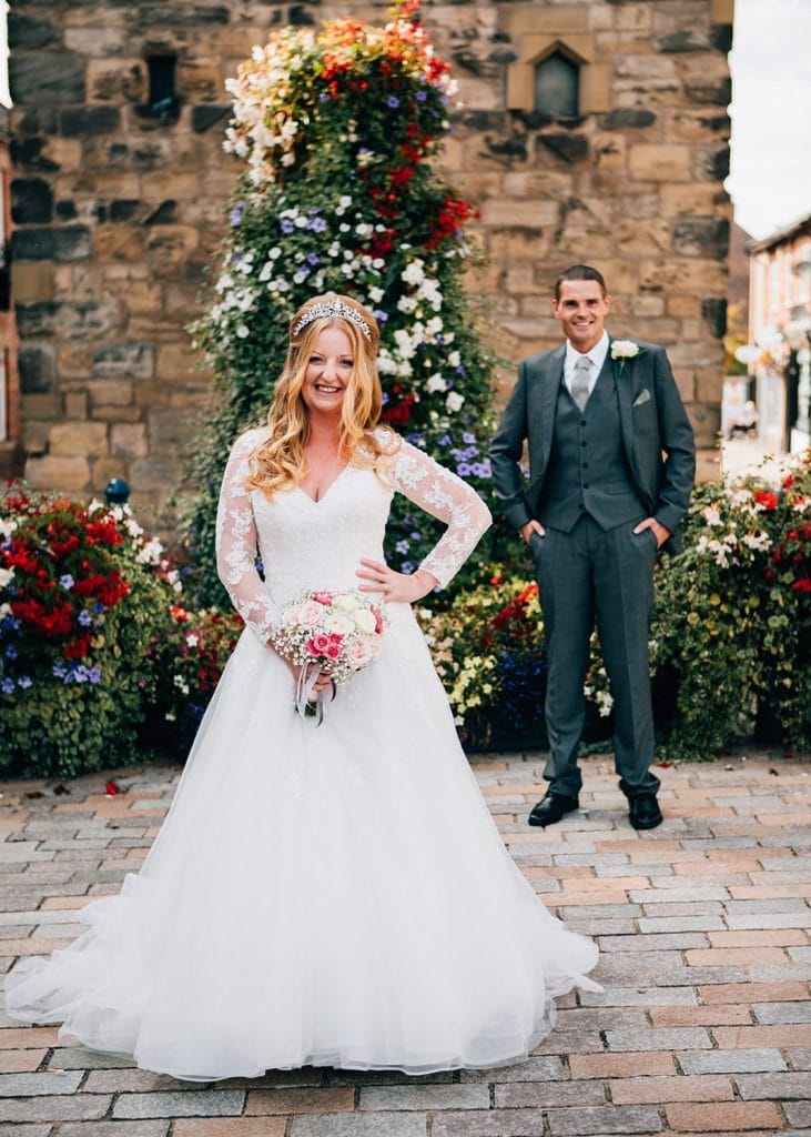 The Groom behind his bride while she poses infront of the Clock Tower in Morpeth, Northumberland