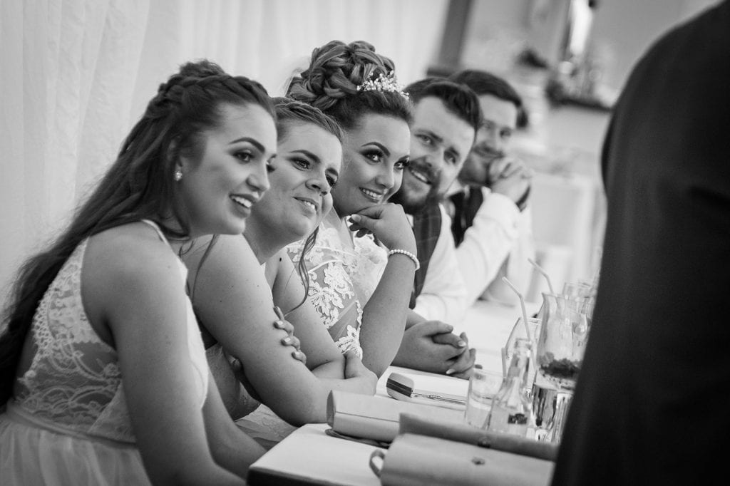 Wedding party laughing at speeches