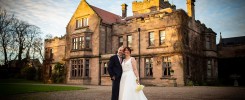 The bride & groom in front of Ellingham Hall in Northumberland