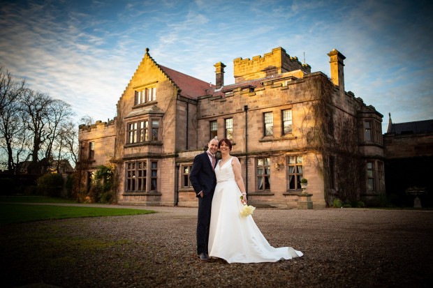 The bride & groom in front of Ellingham Hall in Northumberland